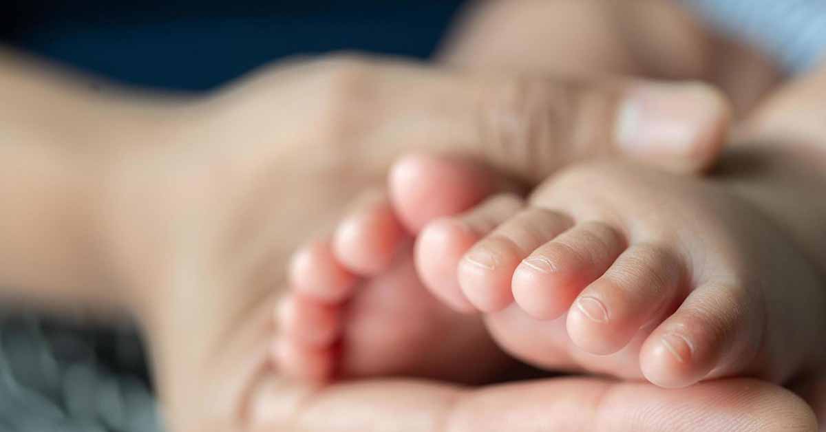 Mother Holding Infant's Feet