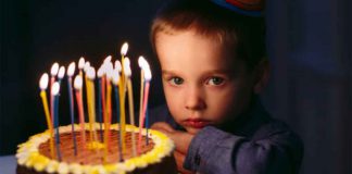 Stock Photo of Sad Boy with Birthday Cake