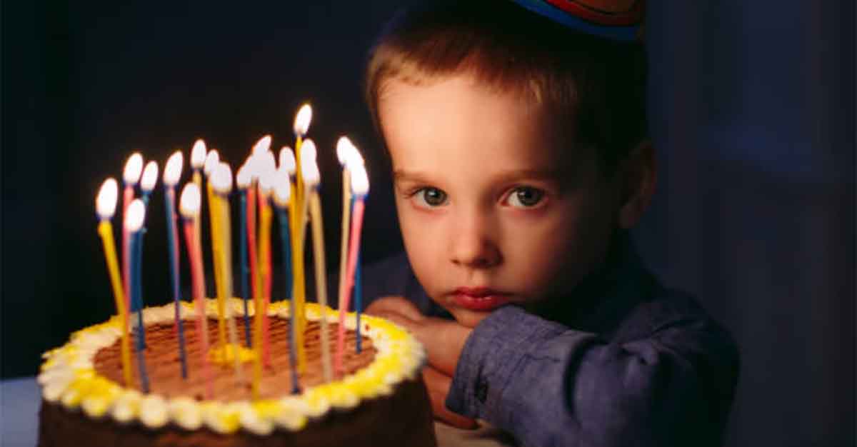 Stock Photo of Sad Boy with Birthday Cake